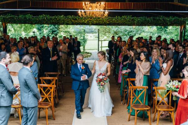 Father of the bride walking down the aisle guests clapping