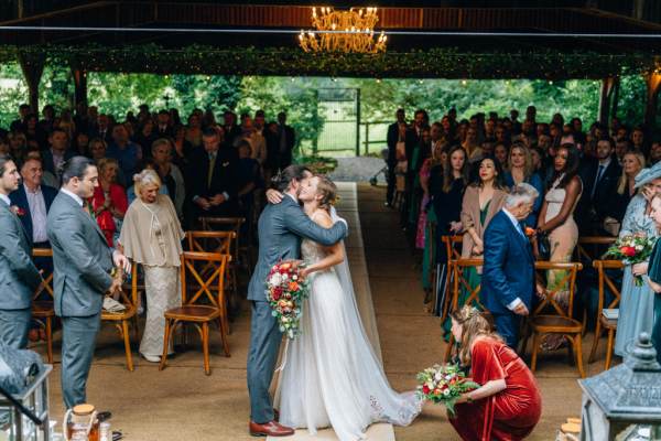 Bride and groom hug at the alter in front of guests