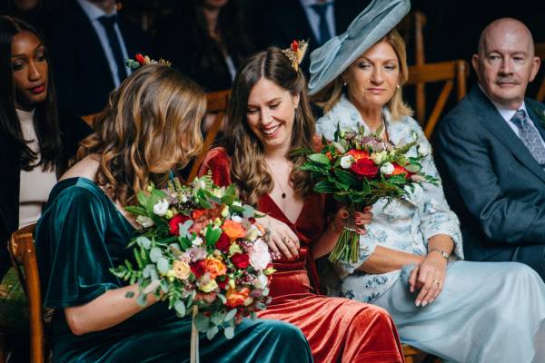 Bridesmaids sitting holding bouquet of flowers