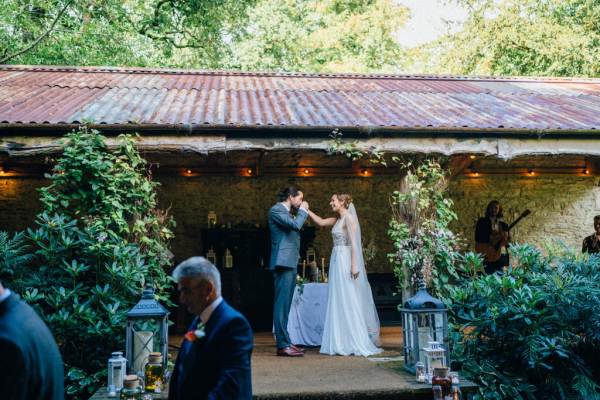 Groom kisses brides hand during ceremony