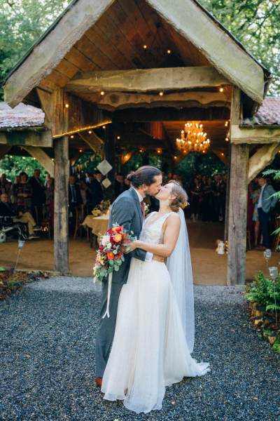 Bride and groom kiss kissing outside venue