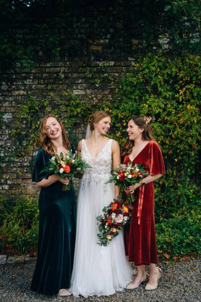 Bride bridesmaids pose for a picture in garden