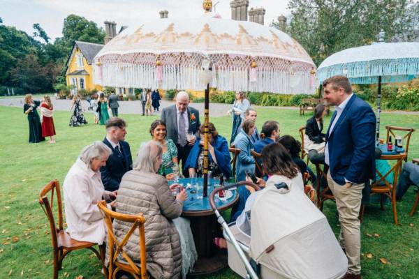 Umbrella over guests sitting atmosphere drinking chatting shot