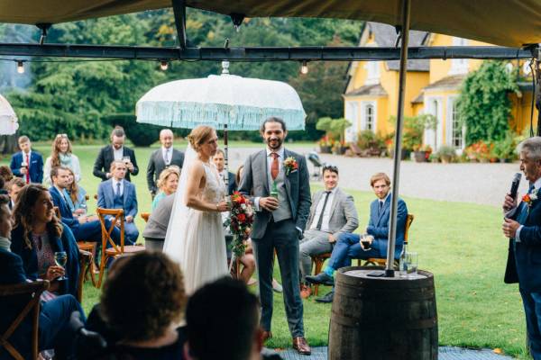 Bride and groom and guests barrel and wooden chairs