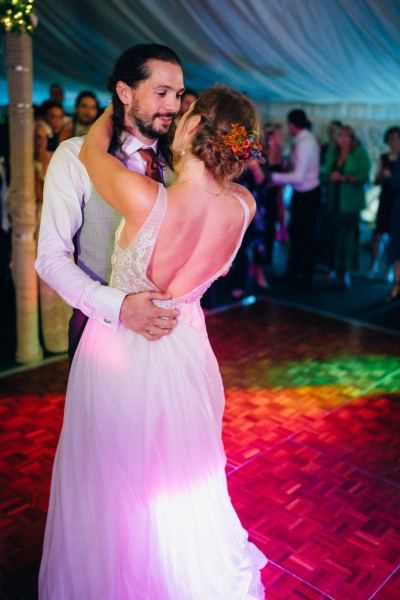 Bride and groom dancing on the dancefloor surrounded by guests