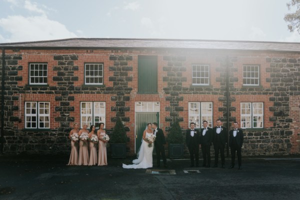 Bridesmaids bride groom and groomsmen outside wedding venue