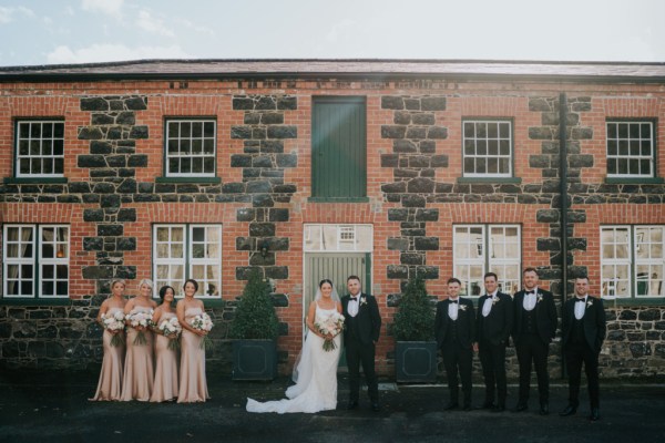 Bridesmaids bride groom and groomsmen outside wedding venue