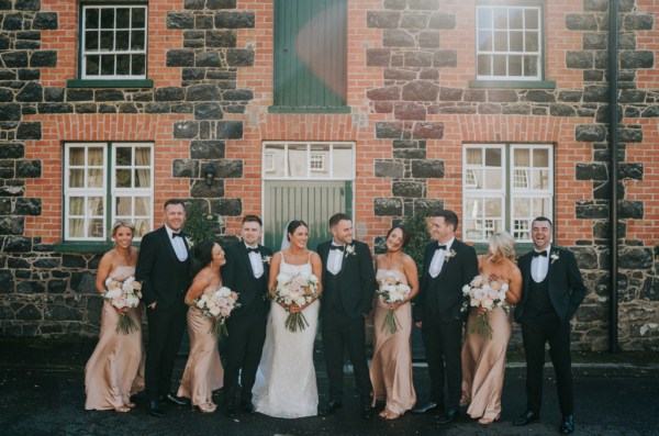 Bridesmaids bride groom and groomsmen outside wedding venue