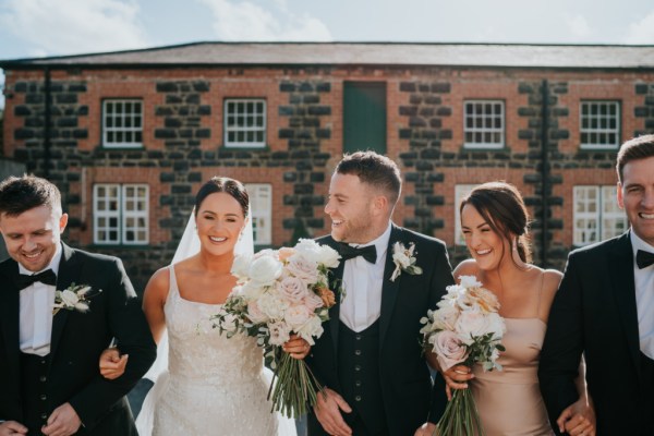 Bridesmaids bride groom and groomsmen outside wedding venue