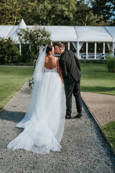 Bride and groom kiss on pathway