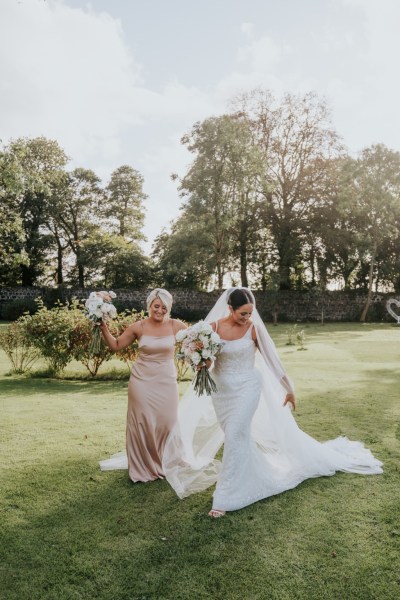 Bride and bridesmaids exterior shot in garden with bouquet of flowers