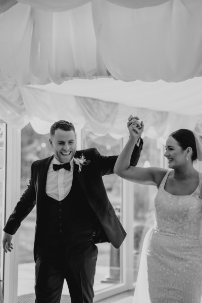 Black and white bride and groom enter the ballroom