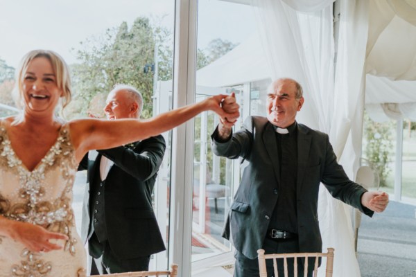 Woman guest and priest at table