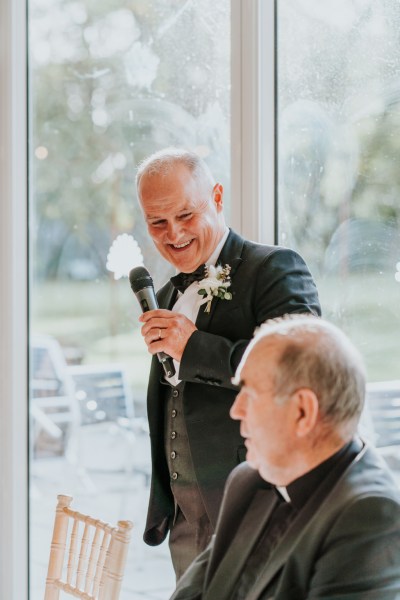 Father give speech priest looks on