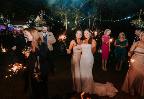 Bride dancing with bridesmaids sparklers