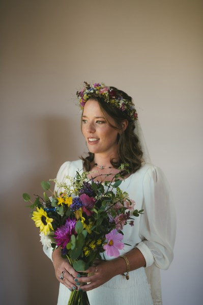 Bride on her own holding bouquet of flowers