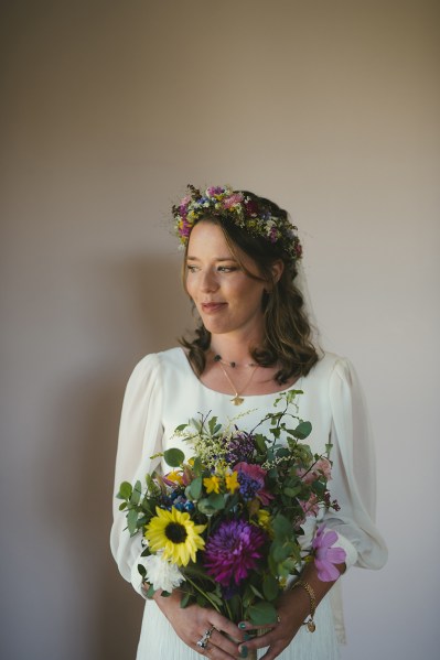 Bride on her own holding bouquet of flowers