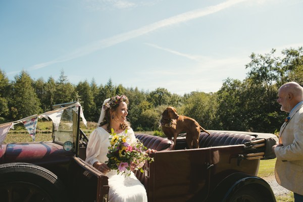 Bride in white sitting in wedding car