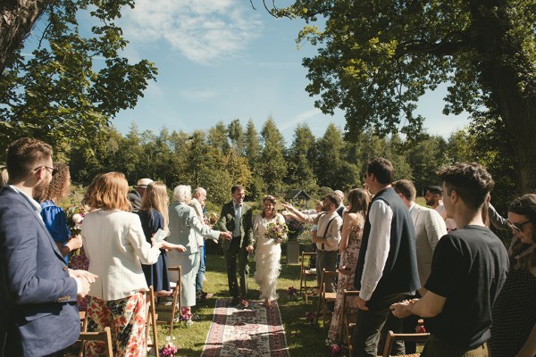 Bride and groom exit wedding ceremony guests clap