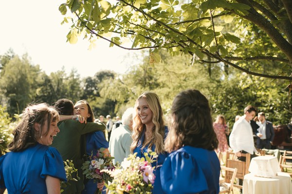 Bridesmaids hold flowers and smile