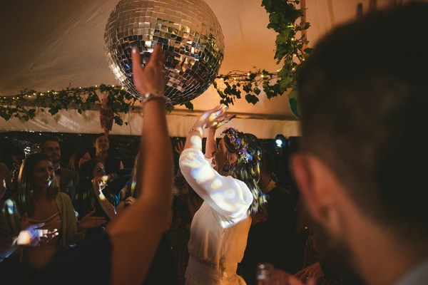 Diamond disco ball hovers over guests on dancefloor