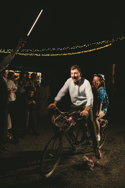 Couple on bicycle on dancefloor in the darkness marquee setting