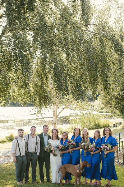 Bride groom bridesmaids and groomsmen best man pose for a picture on the grass in park