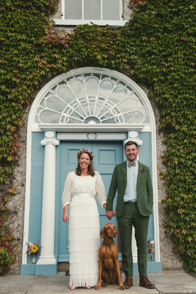 Bride and groom holding hands exterior wedding venue moss and ivy