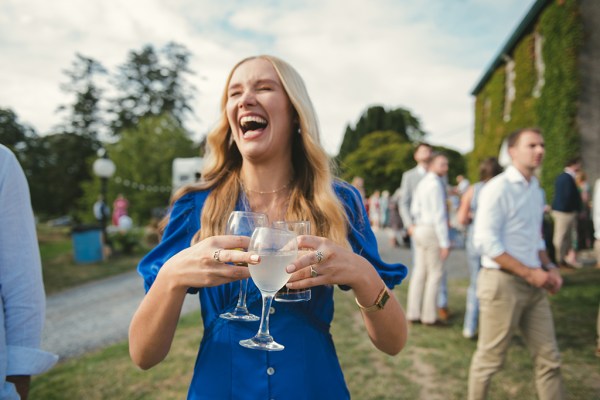 Woman wearing blue dress carrying cocktails alcohol beverages glasses gin