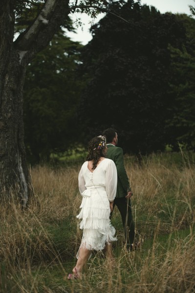 Bride and groom walk through garden