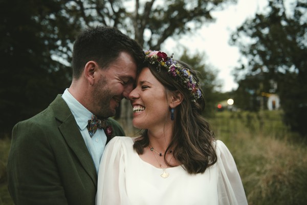 Bride and groom look at each other foreheads touching in garden