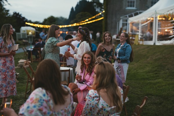 Marquee tent and guests sitting lights in background