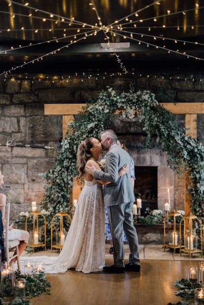 Bride and groom kiss at the alter candles lit ceremony