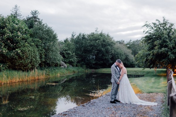 image of couple lake in background head on chest on grass