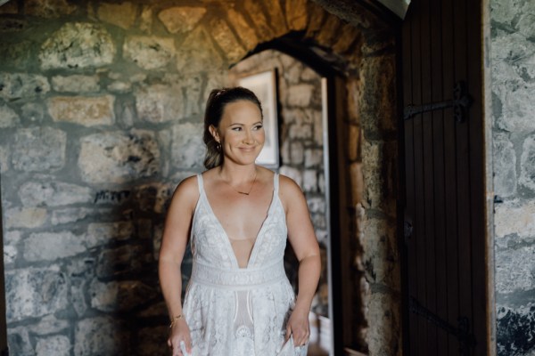 Bride from the front poses in front of bricked wall