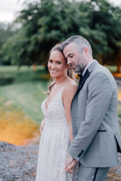 Bride and groom smile in garden together