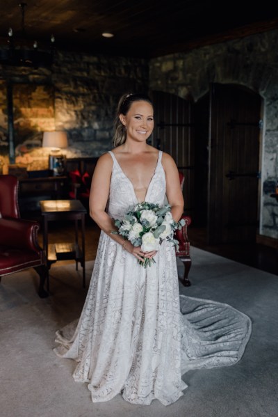 Bride from the front holding bouquet of flowers in room