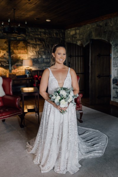 Bride from the front holding bouquet of flowers in room