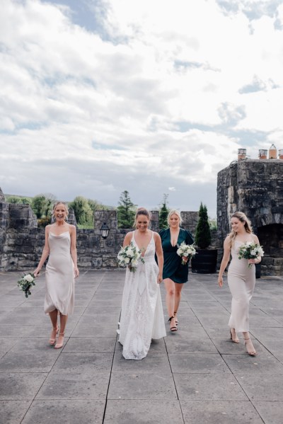 Bridesmaids and bride exterior shot walk together