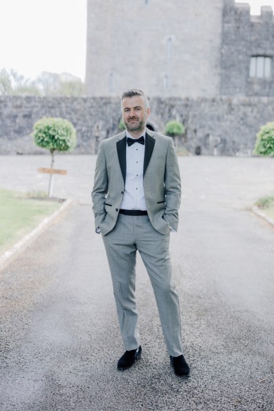 Groom stands alone on pathway