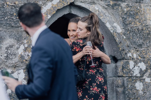 Friend woman hugs bride outside of church