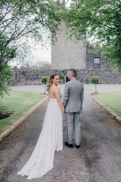 Groom kisses brides cheek as she looks over shoulder