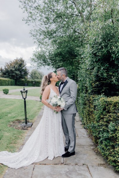 Bride and groom kiss on the pathway