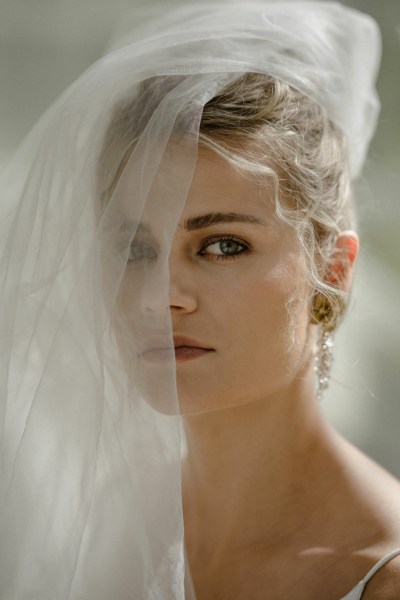 Close up of blonde curly haired woman wearing veil covering face