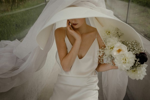 Bride with large white hair hat accessory veil silky dress flowers roses makeup detail