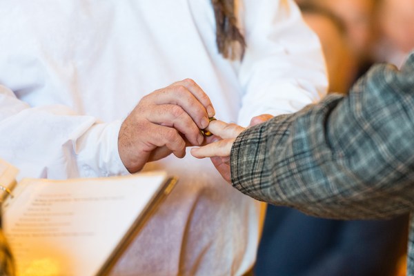 Grooms exchange wedding bands hands