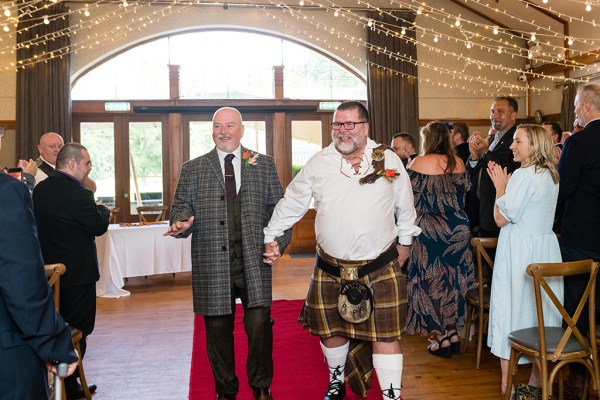 Grooms walk down the aisle red carpet guests clap