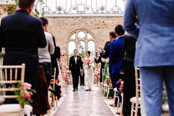 Bride and groom walk out of ceremony smiling