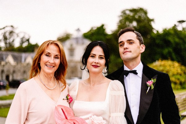 Bride groom and mother pose for a picture