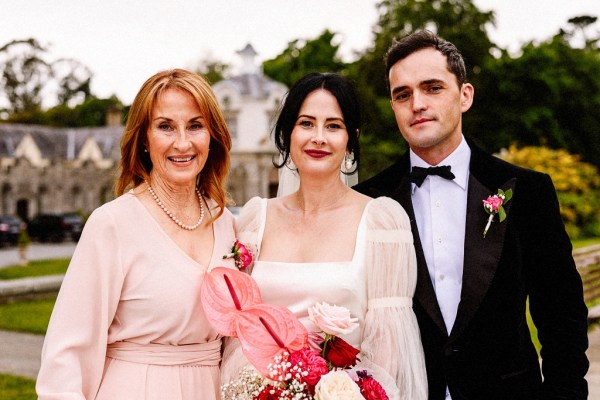 Bride groom and mother pose for a picture